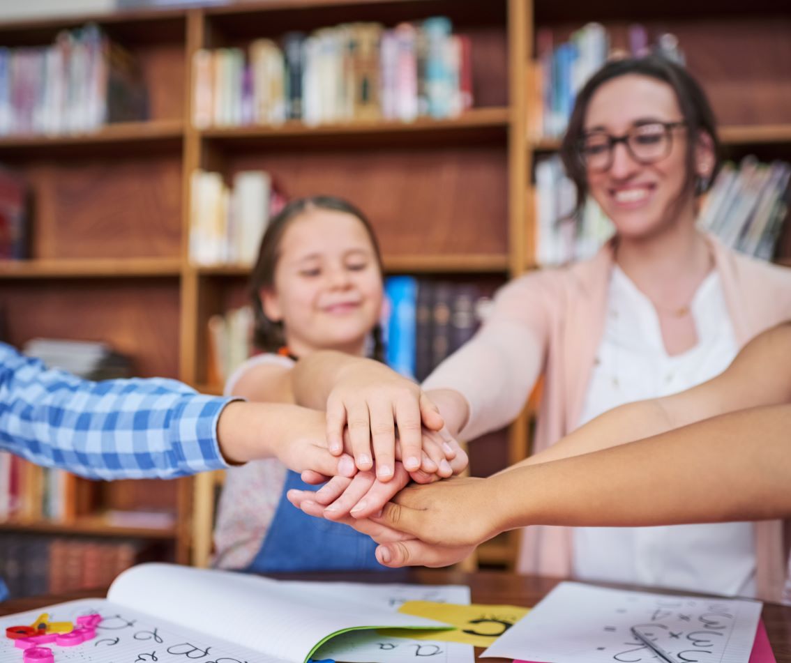 Foto de alunos unindo forças e sendo colaborativos